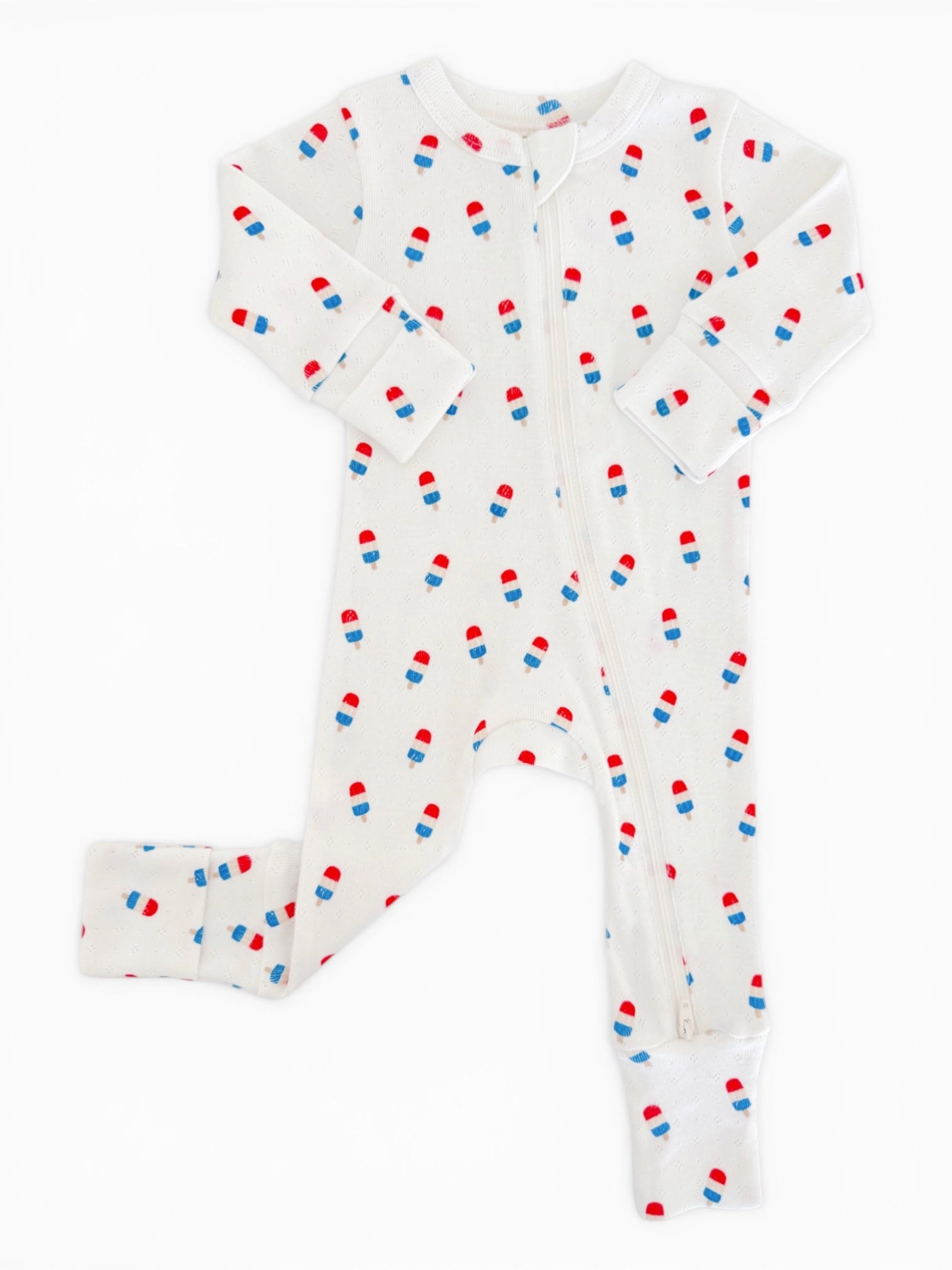 White baby onesie with red and blue popsicle pattern, featuring long sleeves and a zipper closure.