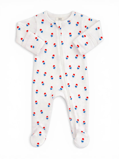 White baby onesie with red and blue pill print, featuring a front zipper and footed design.