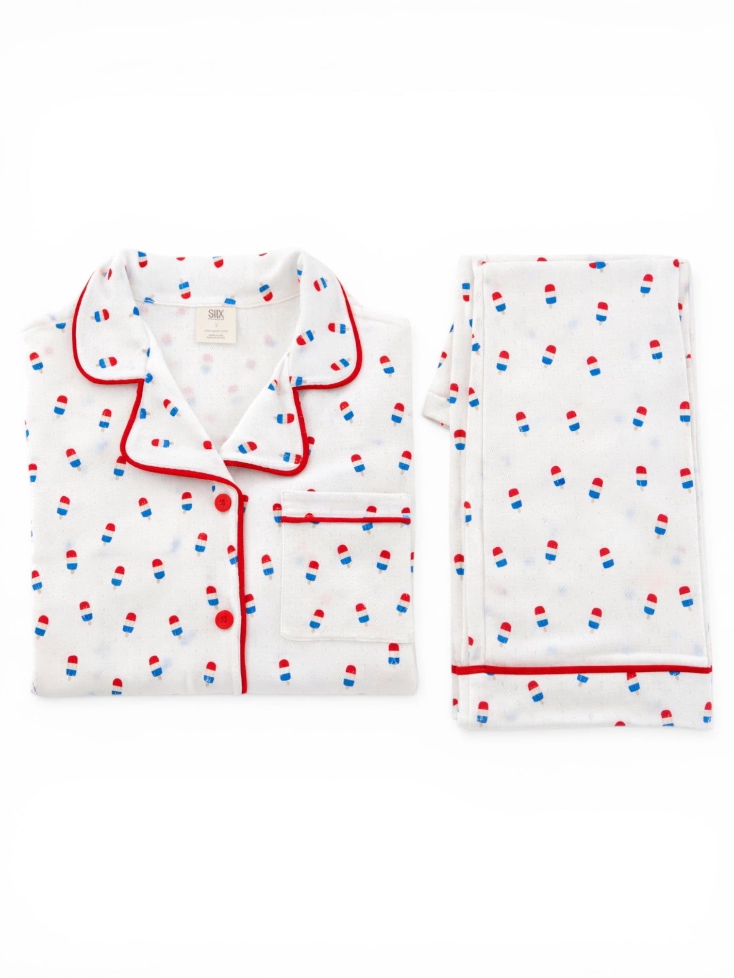 White pajama set with red and blue pill pattern, includes top and folded pants on a white background.