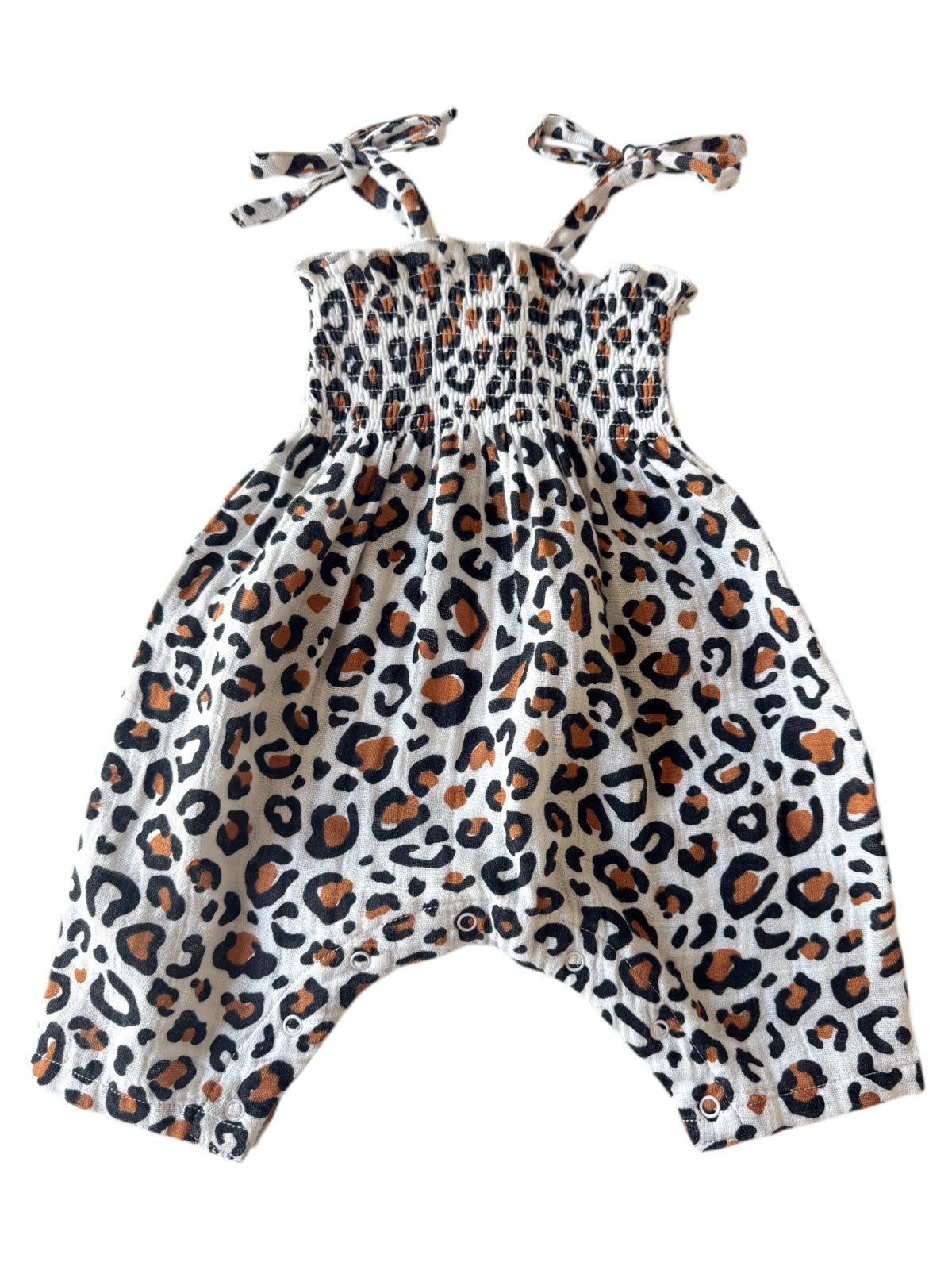 Leopard print baby romper with smocked bodice and bow straps, featuring snap closures at the bottom.
