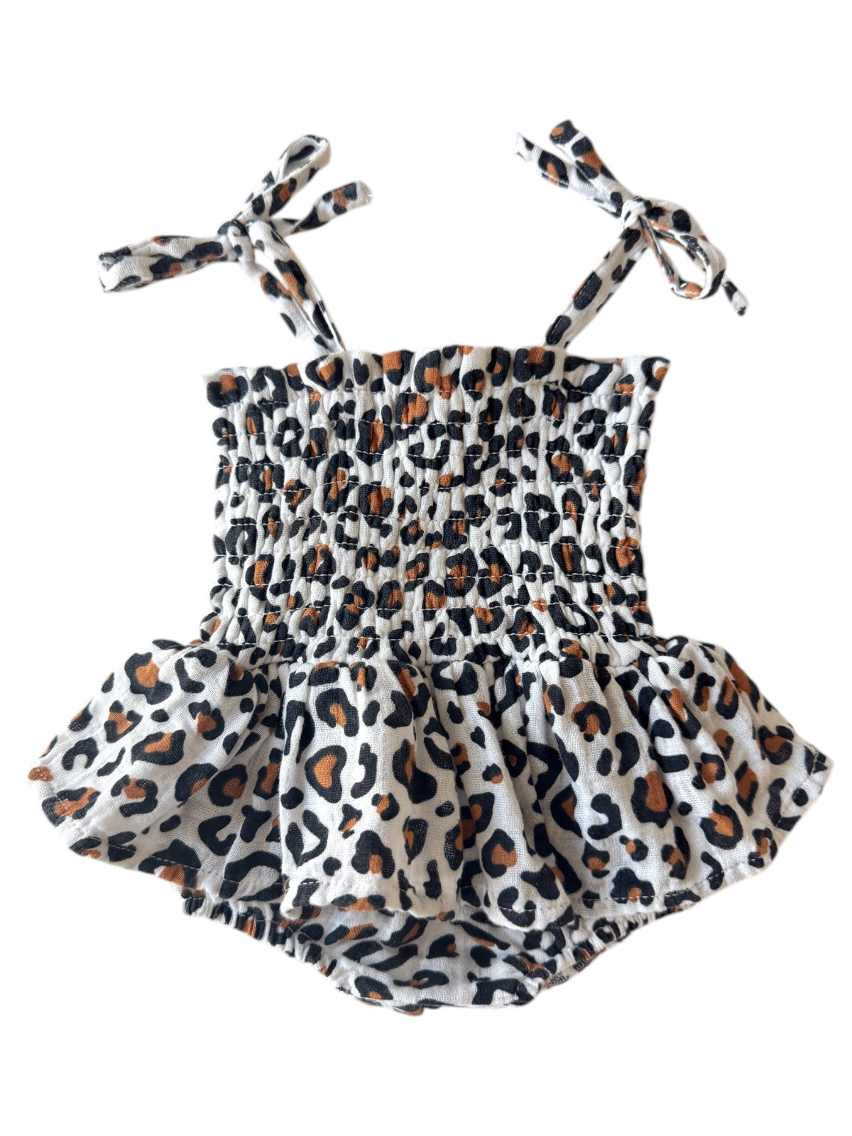 Leopard print romper with smocked bodice and tie straps, featuring a flared skirt. Perfect for summer wear.