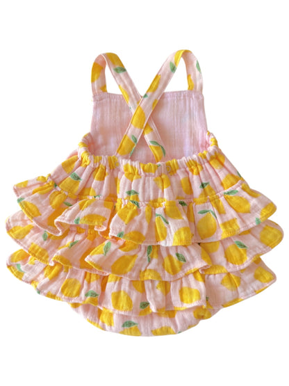 Pink ruffled dress with lemon print and crossed straps, perfect for summer.