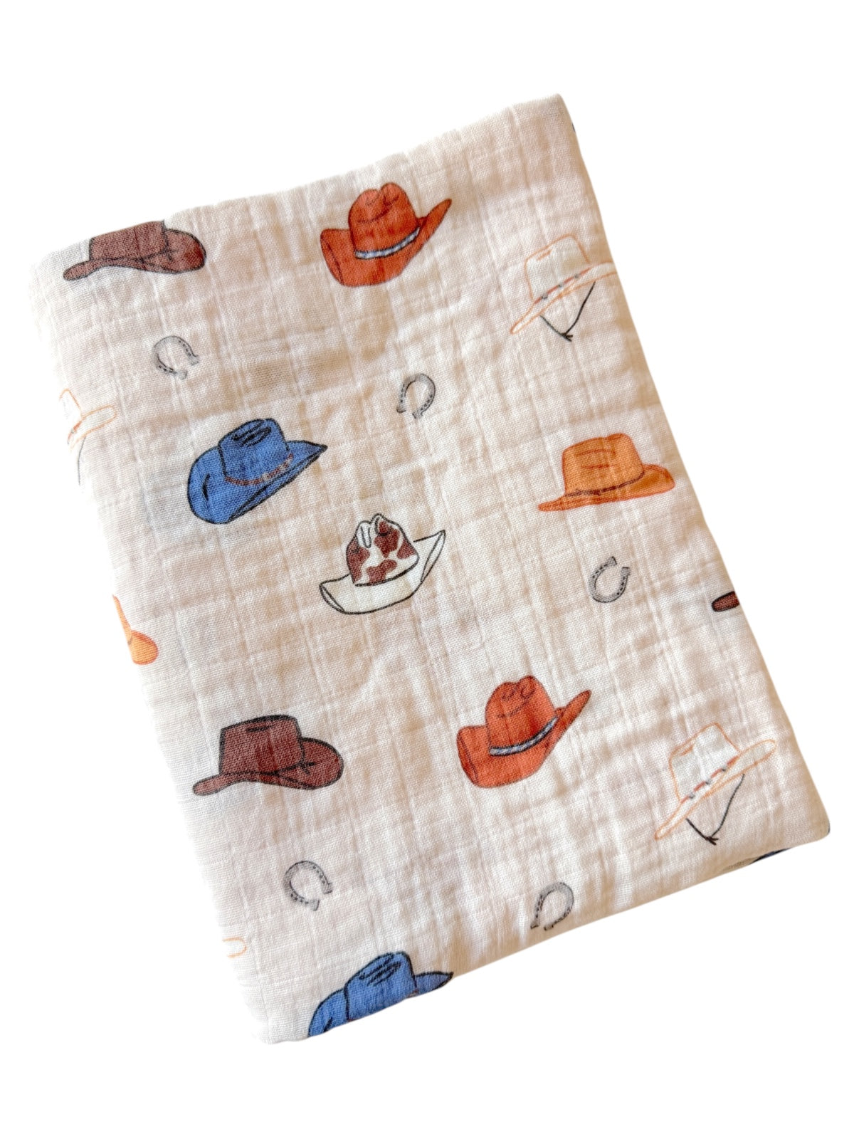 Patterned fabric featuring various cowboy hats and horseshoes in warm colors on a light background.
