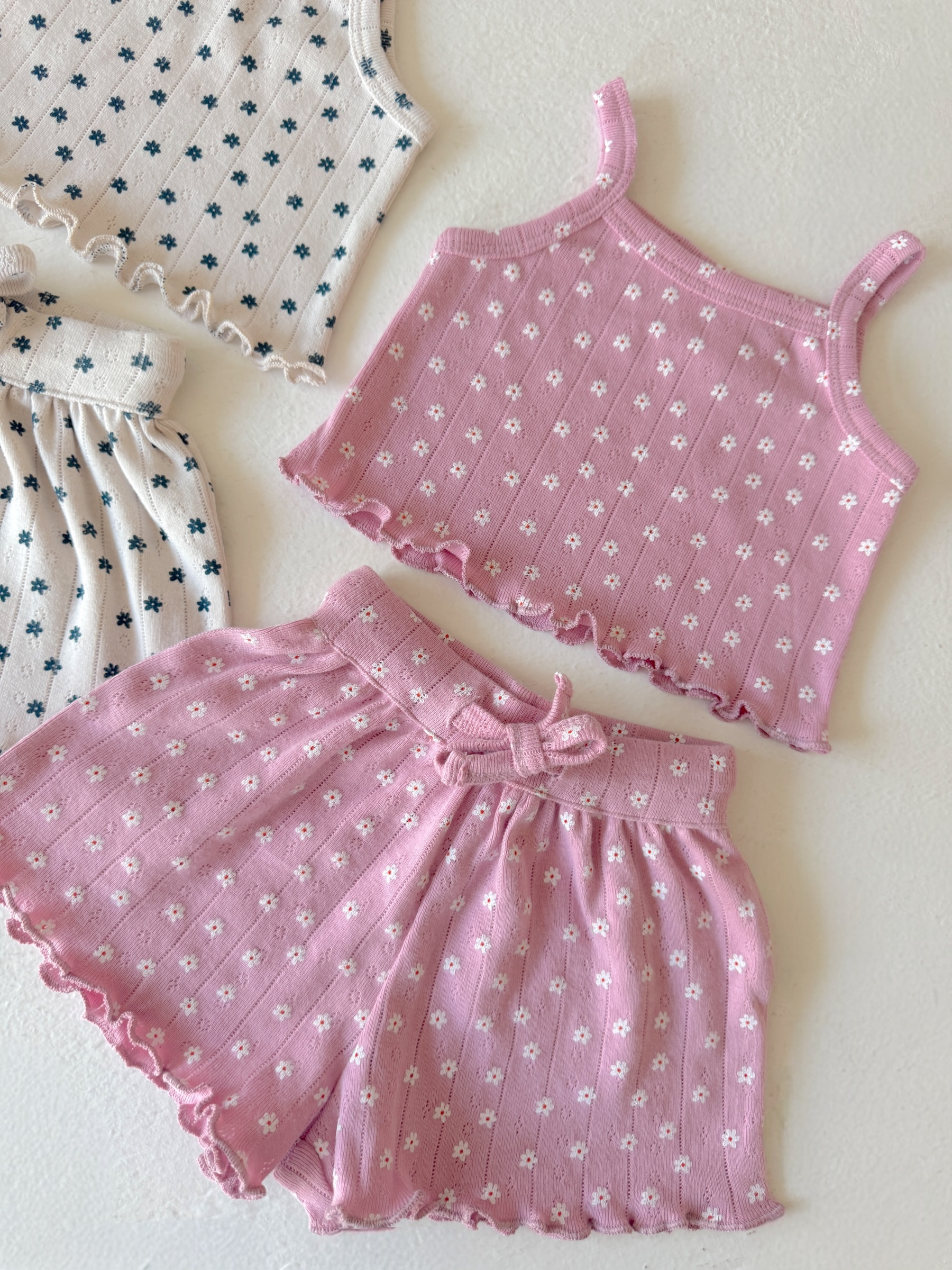 Pink floral tank top and shorts set, with a frilled hem and matching design on a light background.