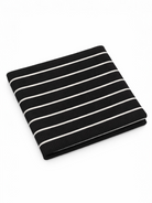 Black and white striped fabric folded neatly on a flat surface.
