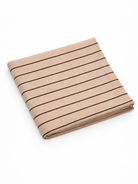 Folded beige fabric with vertical black stripes on a white background.
