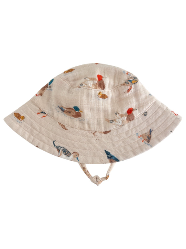 Beige bucket hat with colorful bird prints, featuring a wide brim and chin strap. Ideal for sun protection.