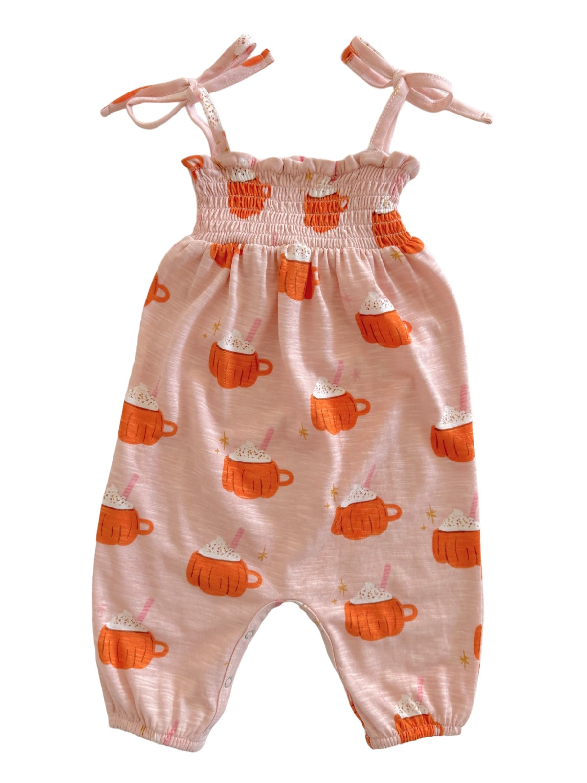 Light pink romper with orange mugs and cream designs, featuring tie straps and gathered waist. Perfect for kids.