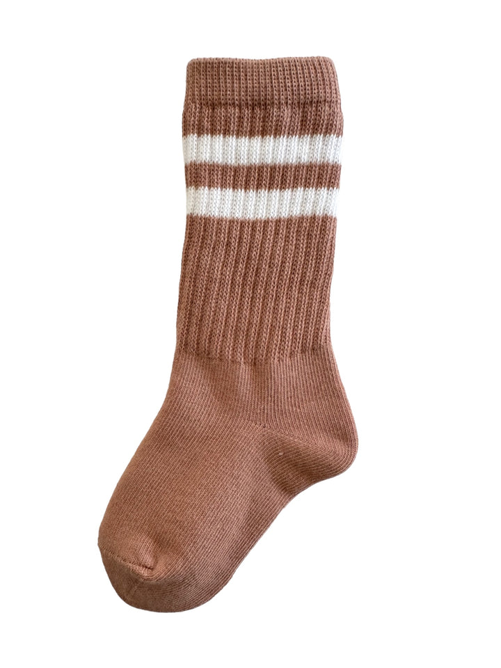 Brown ribbed sock with white stripes, displayed upright against a white background.
