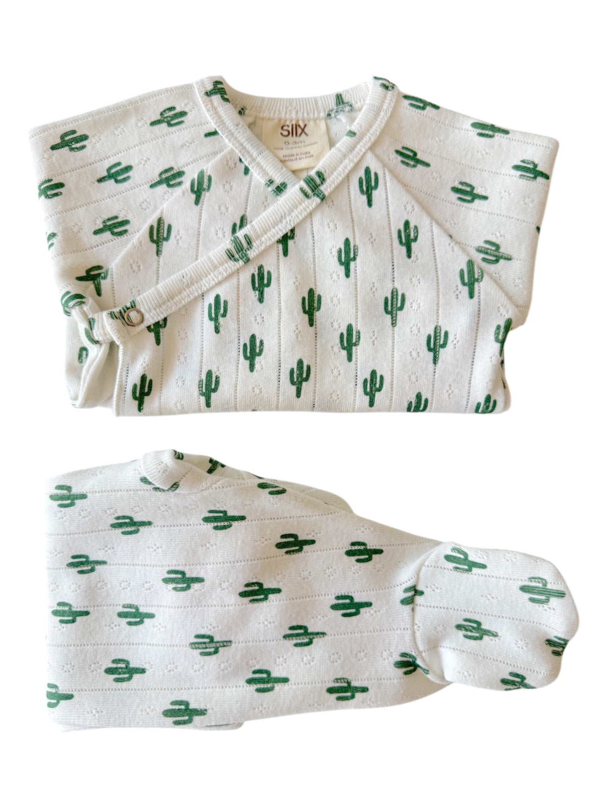 Cactus-patterned baby outfit featuring a wrap top and matching bottom, in soft white fabric with green designs.