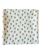 White fabric with a repeating green cactus pattern, folded neatly for display.
