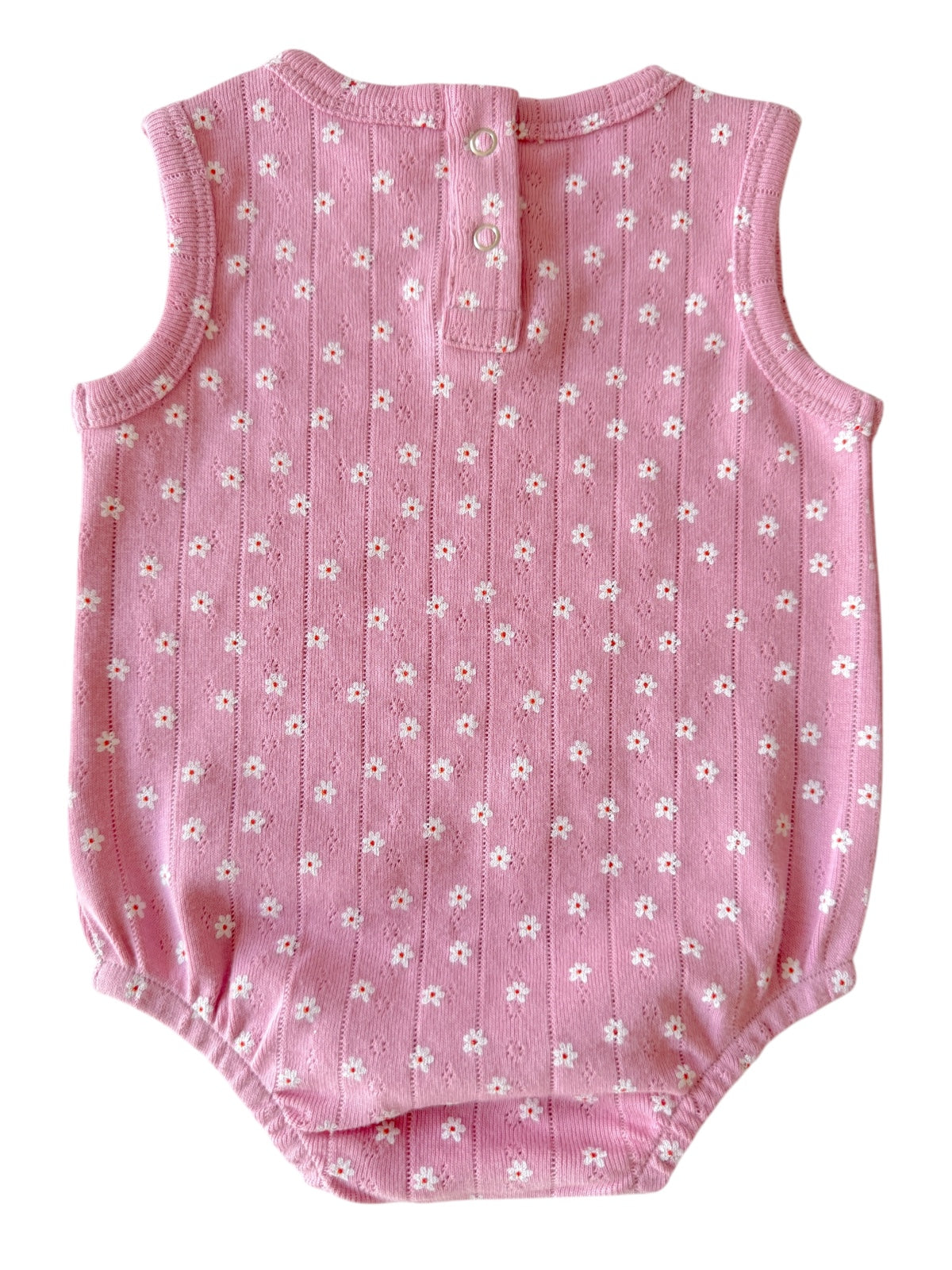 Pink baby onesie with small white floral pattern, featuring a button closure at the back.
