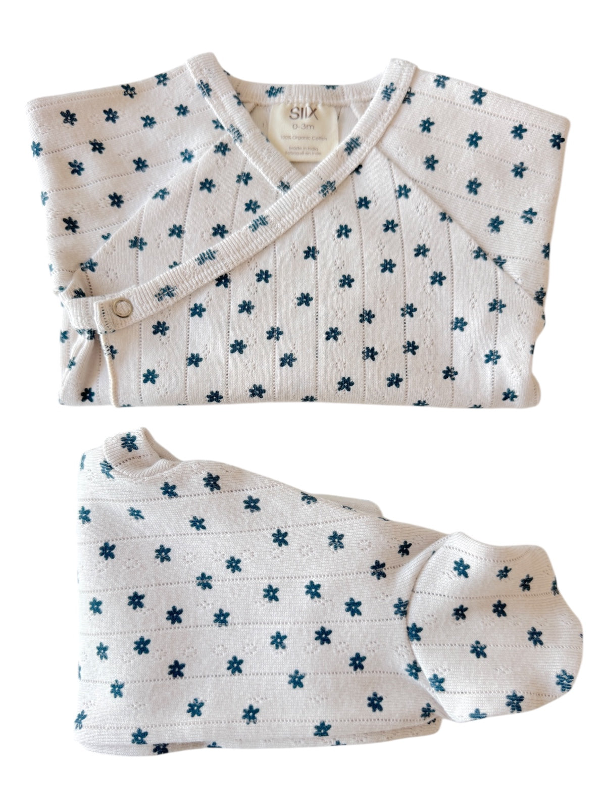 White baby outfit with blue floral pattern, including a wrap top and matching pants. Suitable for infants.