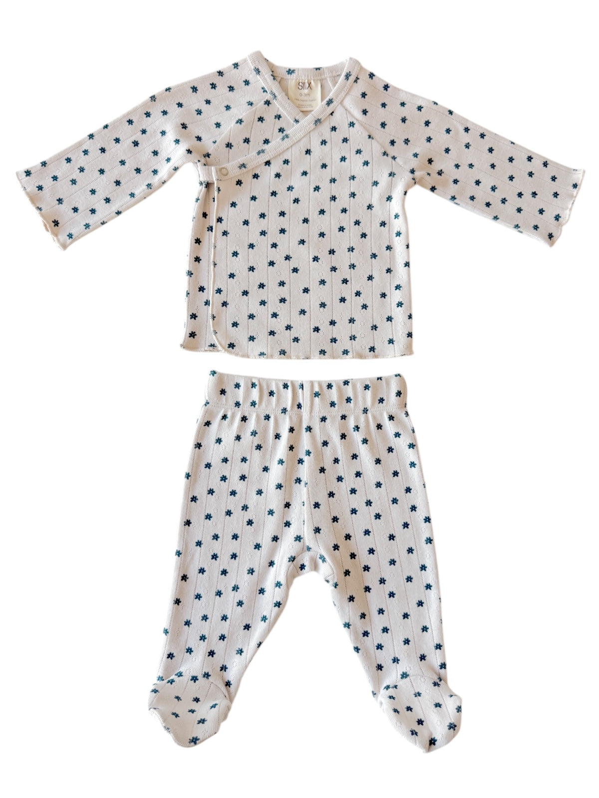 White baby outfit with navy floral print, featuring a wrap top and matching pants, ideal for newborns.