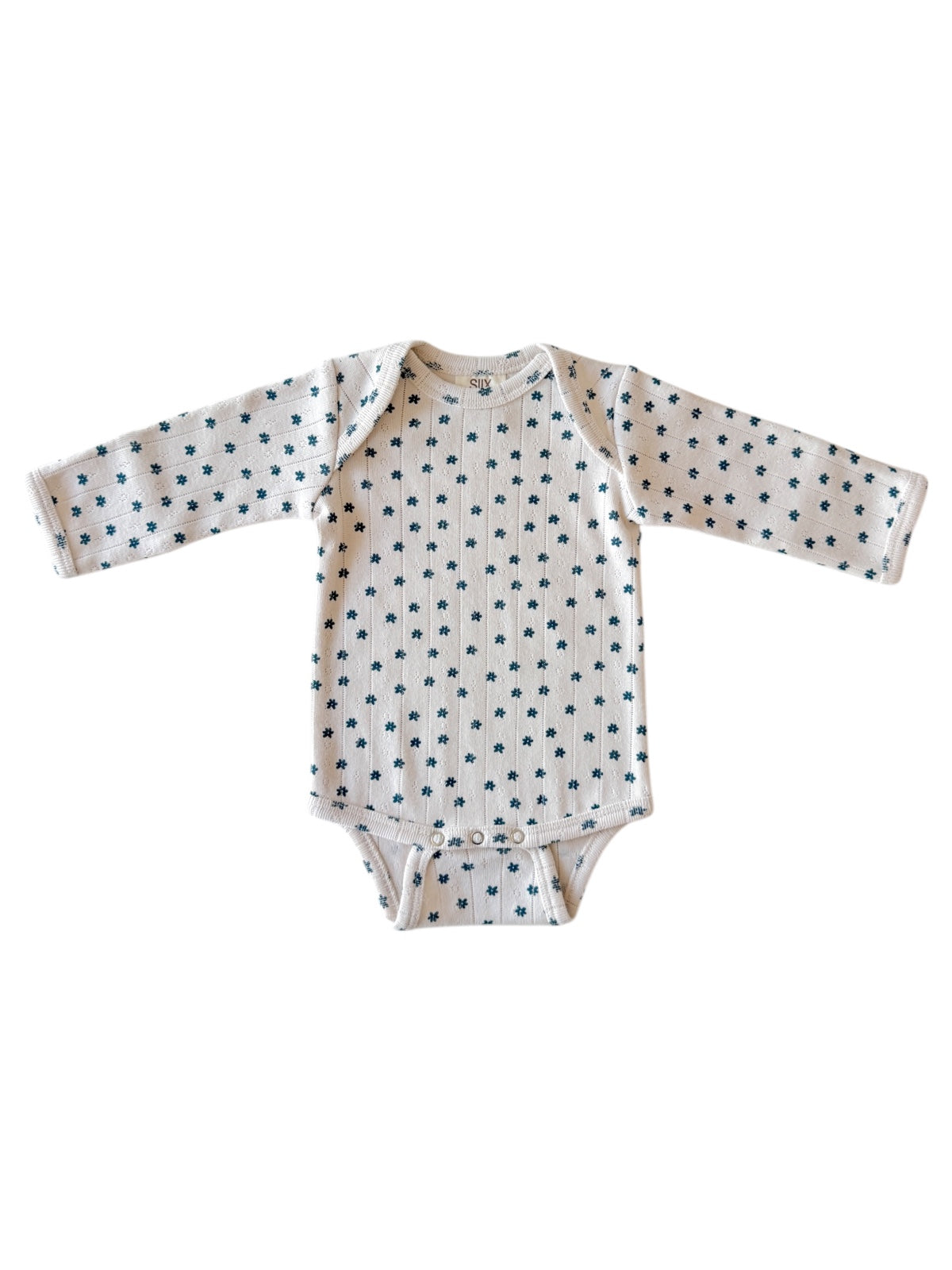 White long-sleeve baby onesie with small blue floral patterns on the fabric.
