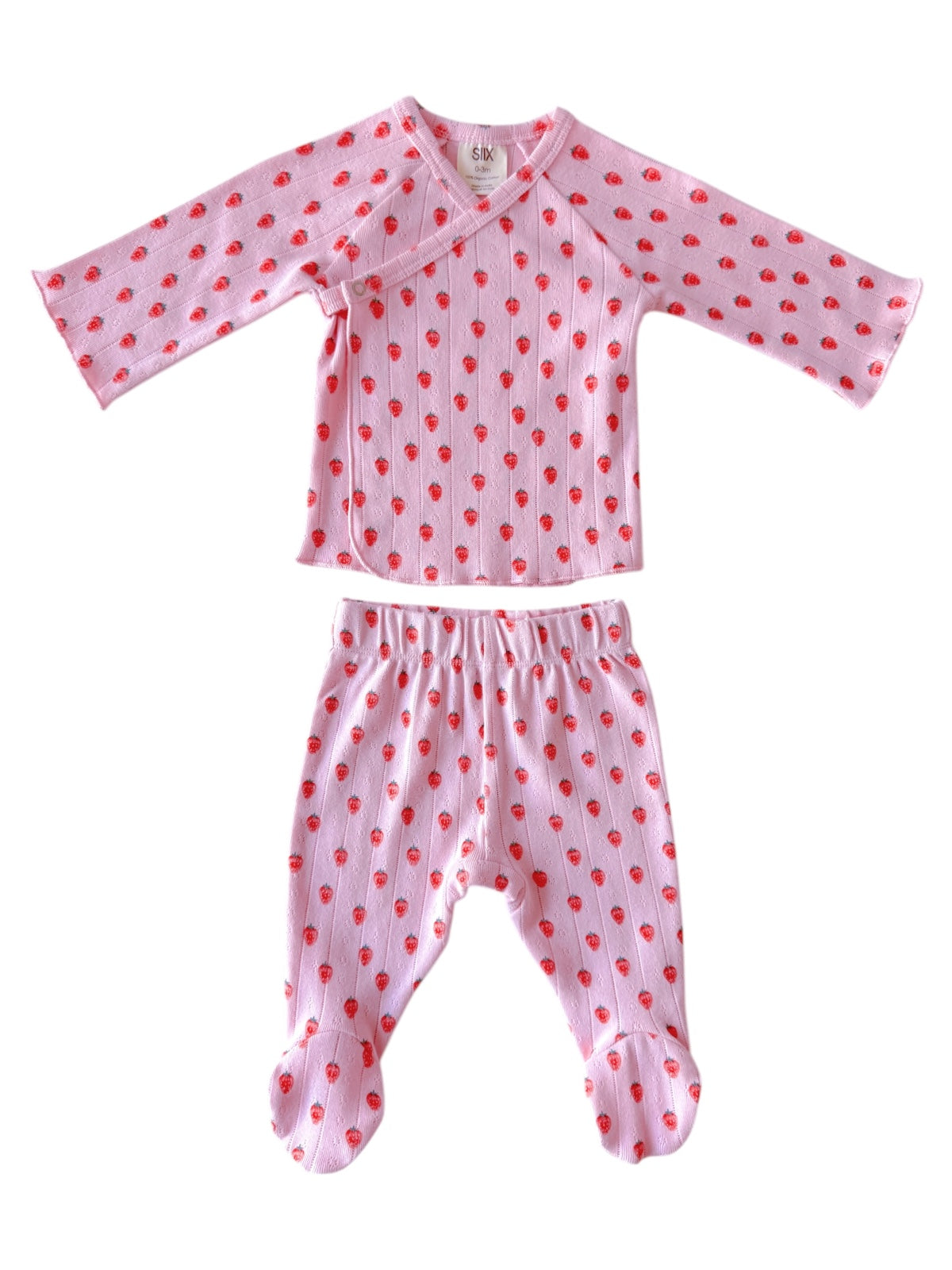 Pink children's pajama set features long sleeves and patterned with small red hearts. 