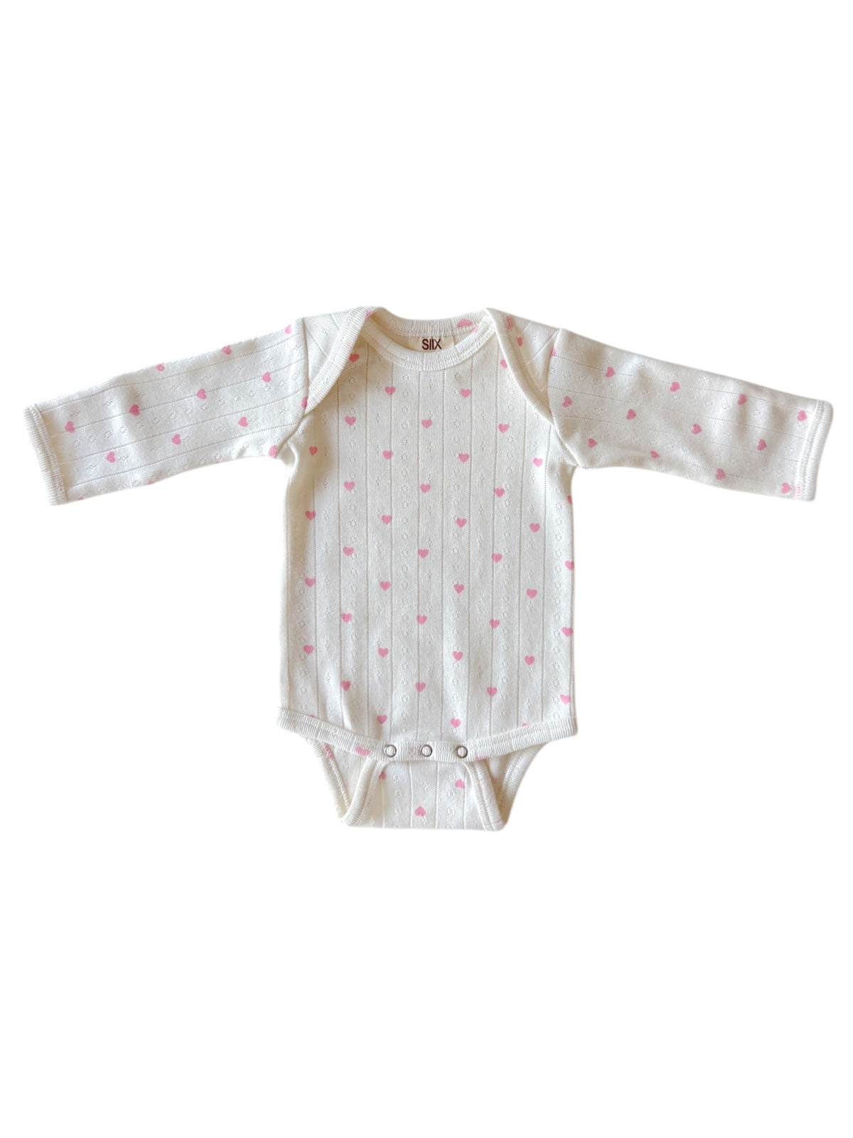 White baby bodysuit with pink heart patterns and long sleeves. Ideal for infants.
