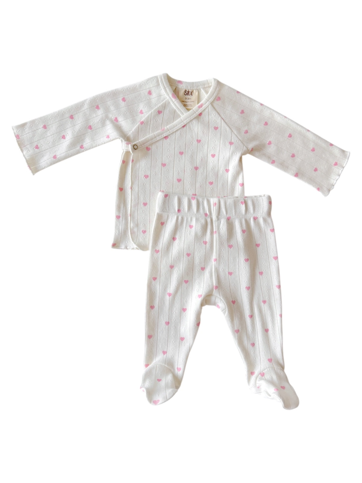 White baby outfit with pink hearts, including a long-sleeve top and matching pants. Perfect for newborns.