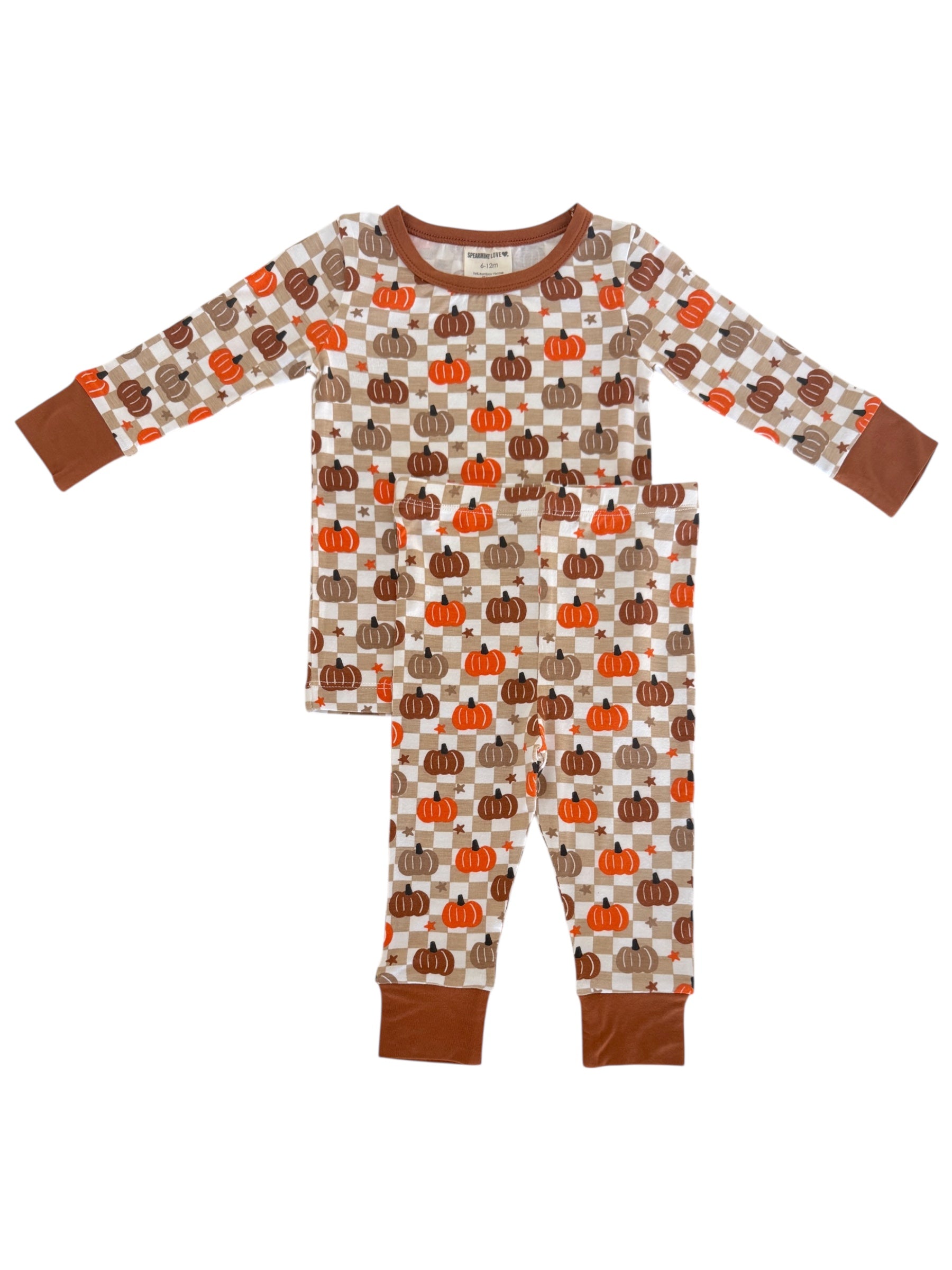 Kids' pajamas with pumpkin print in warm colors, featuring long sleeves and elastic waistband pants.