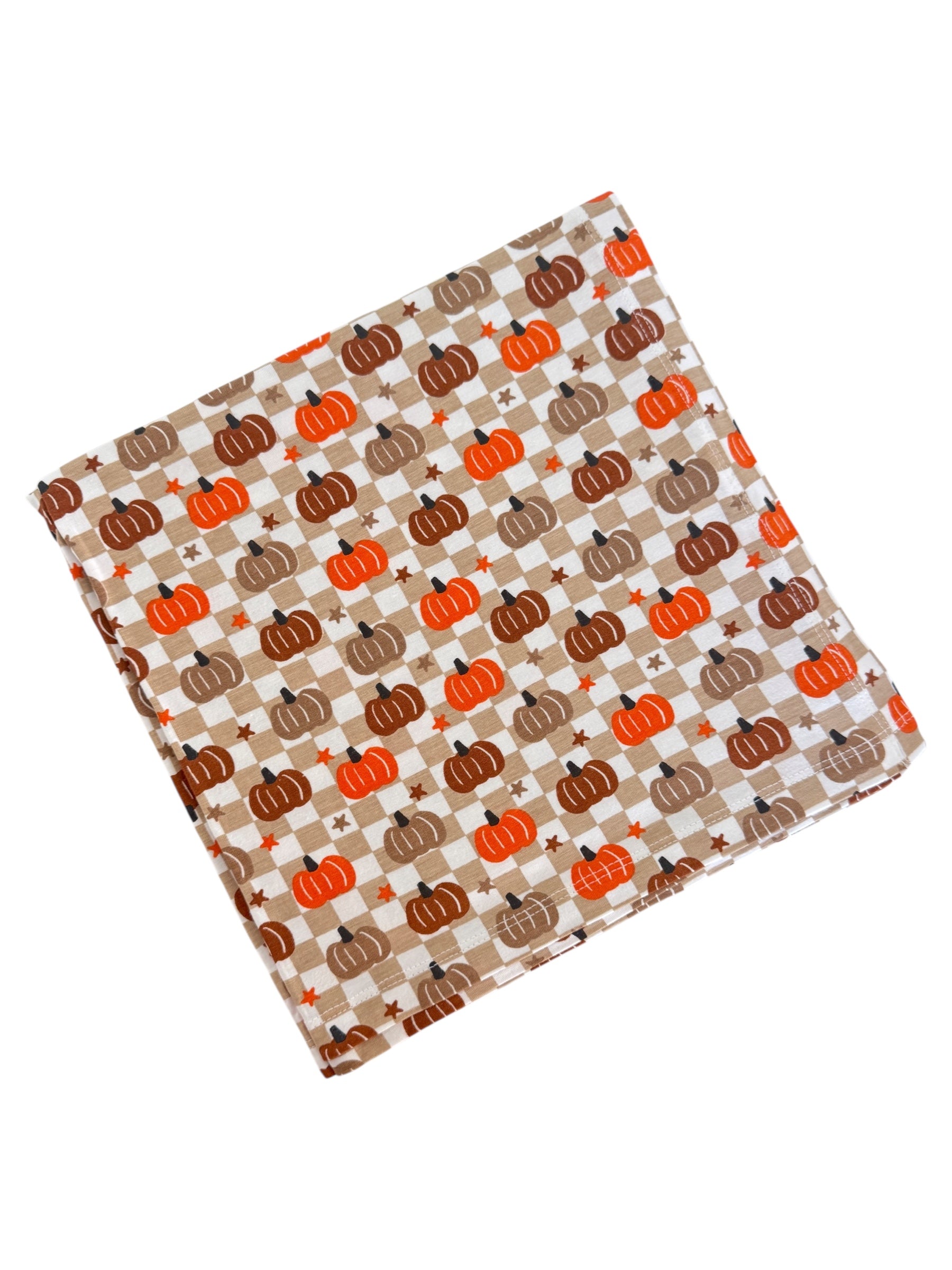 Fabric square with an orange and brown pumpkin pattern on a checkered background. Ideal for fall décor or crafts.