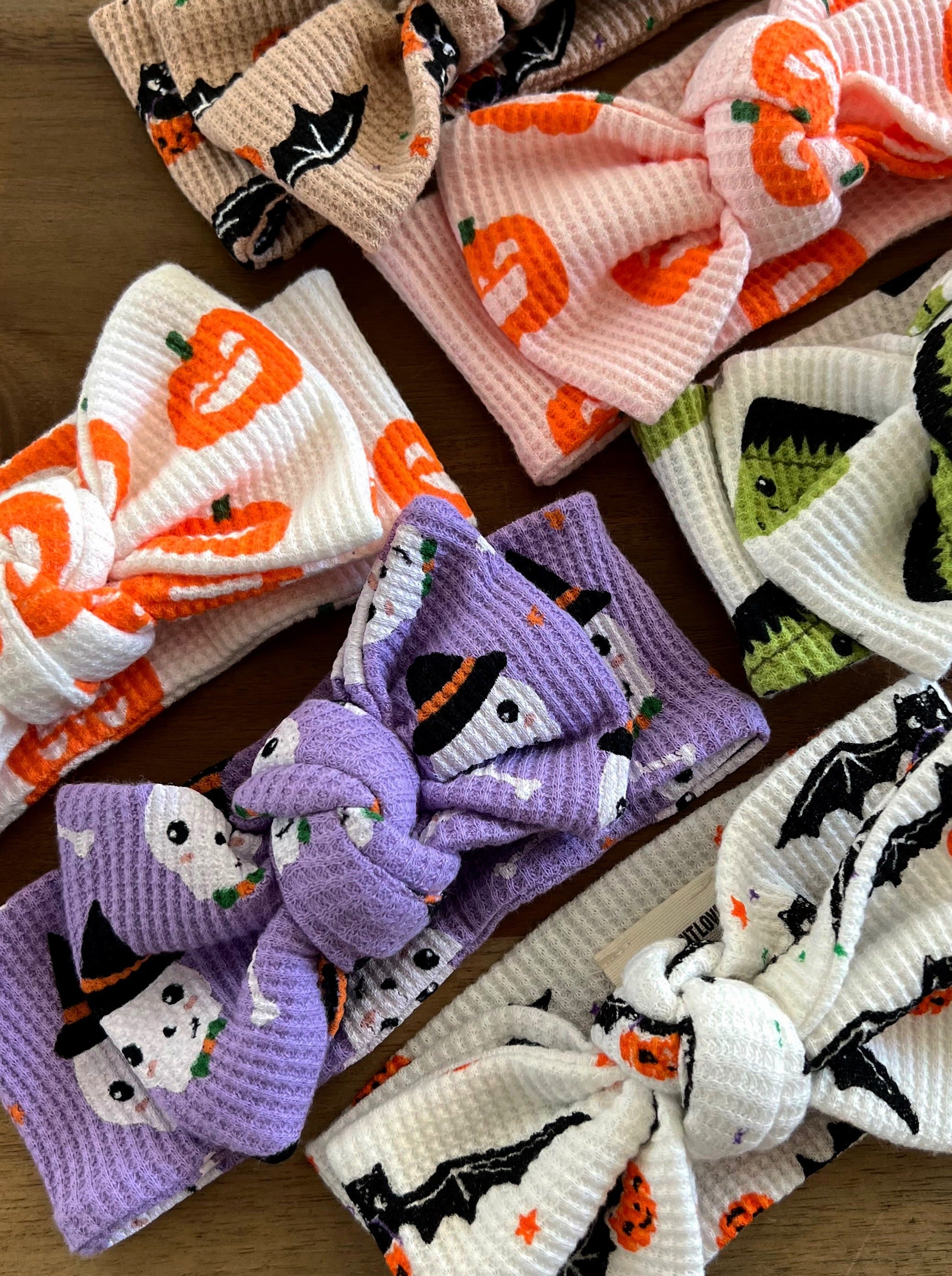 Colorful Halloween-themed headbands with assorted designs, including pumpkins, ghosts, and bats.
