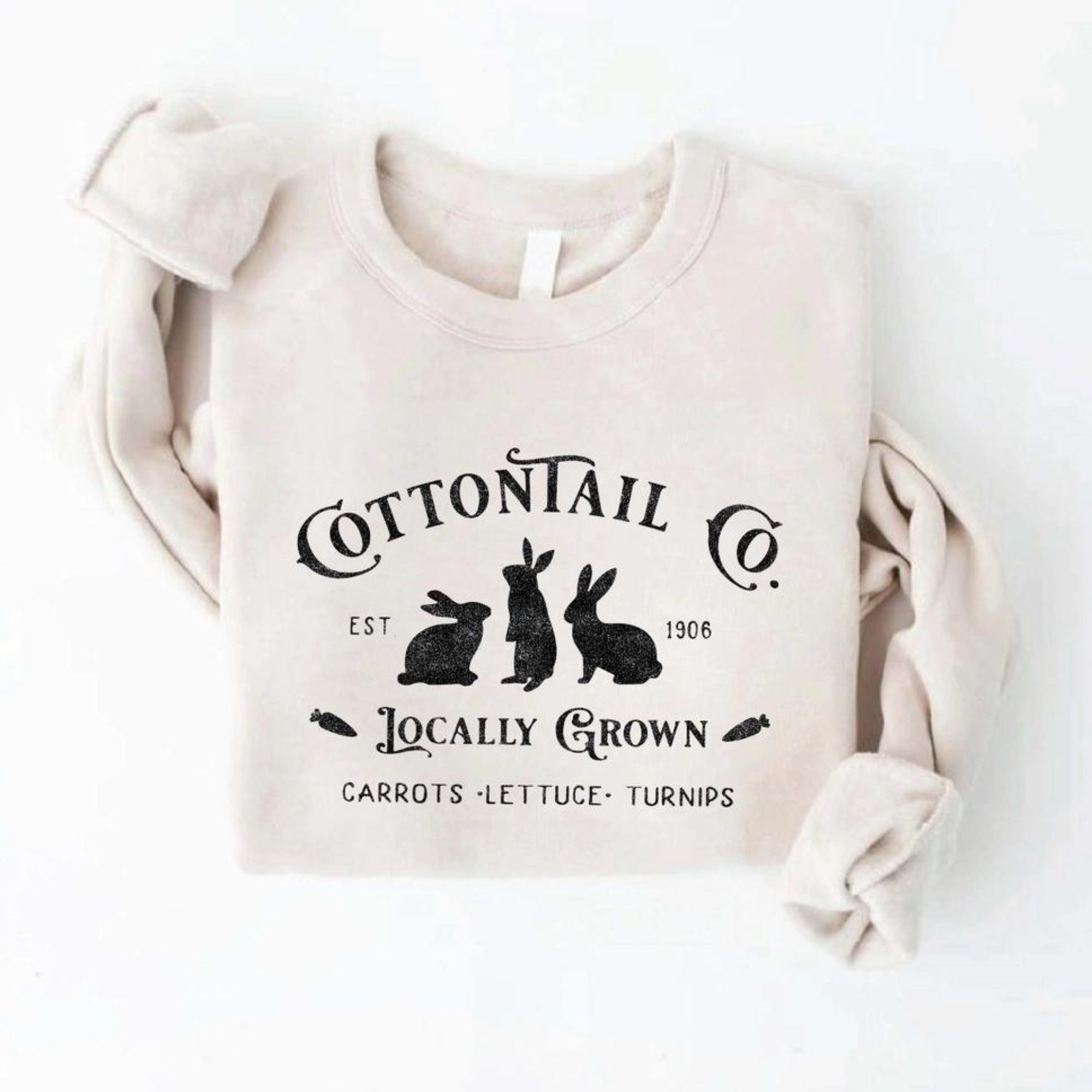 Light beige sweatshirt featuring a graphic of three rabbits and the text "Cottontail Co. Locally Grown."