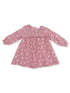 Pink floral dress with long sleeves and smocked bodice, perfect for casual outings or special occasions.