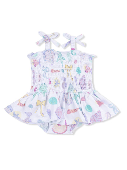 Girls' swim dress with pastel seashell print and bow straps, featuring a flared skirt and matching bottom.