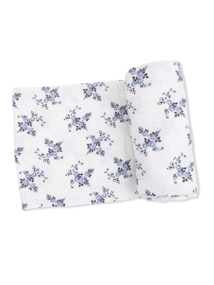 White fabric with blue floral pattern, neatly rolled and laid flat for display. Ideal for sewing and crafting projects.