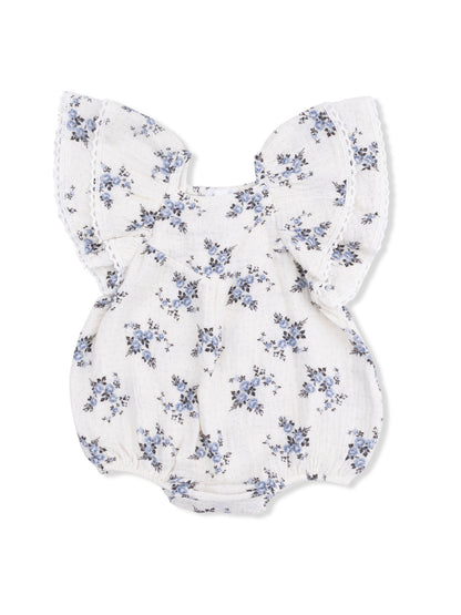 Floral baby romper with wide sleeves and gathered waist in soft white fabric with blue flowers.