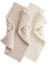 Neutral-colored textured towels folded together, one beige and one white, showcasing their soft, cozy fabric.
