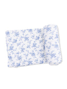 Floral-patterned fabric with light blue flowers on a white background, displayed flat and rolled.