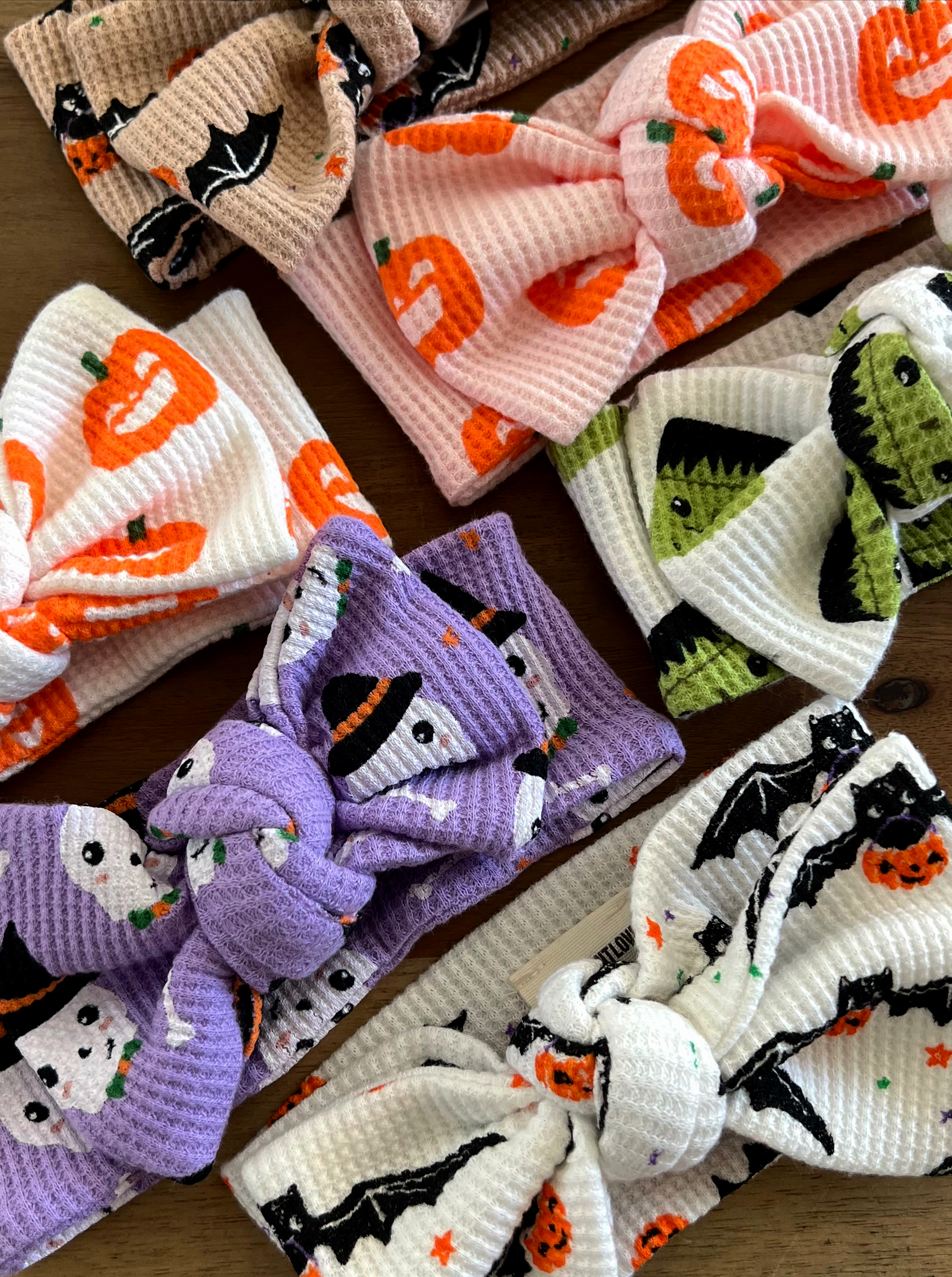 Colorful Halloween-themed headbands with various patterns including pumpkins, ghosts, and bats.