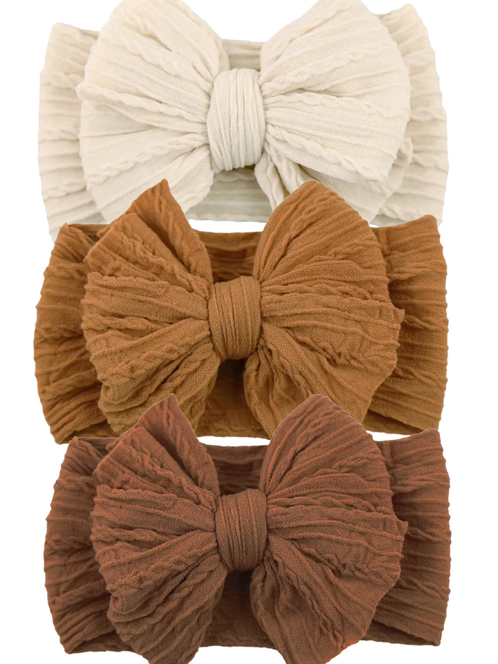 Three textured hairbands in cream, light brown, and dark brown, each featuring a large bow design.
