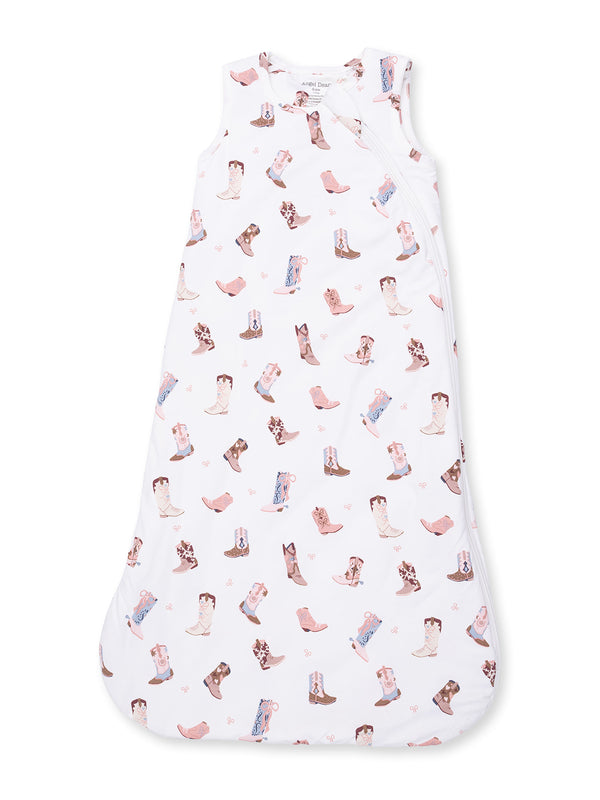 White baby sleeping sack with a playful cowboy boot pattern in soft pastel colors.