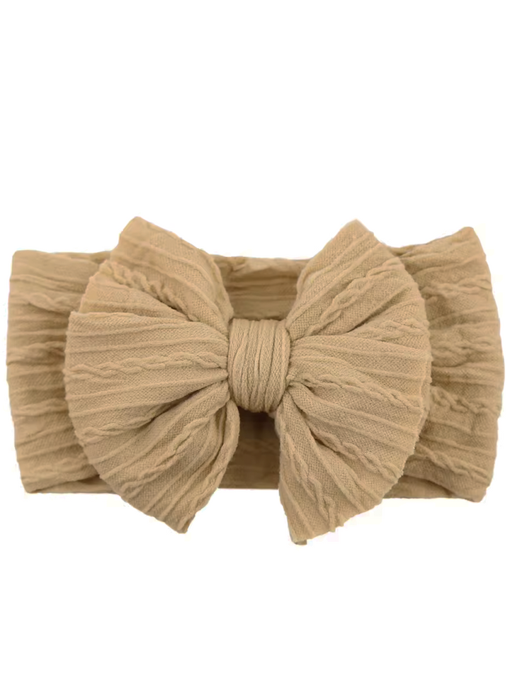Light beige fabric headband with a large textured bow in the center. Perfect for stylish hairdos.