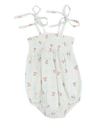 Light blue baby romper with cherry print and tie straps. Features smocked bodice and snaps for easy dressing.