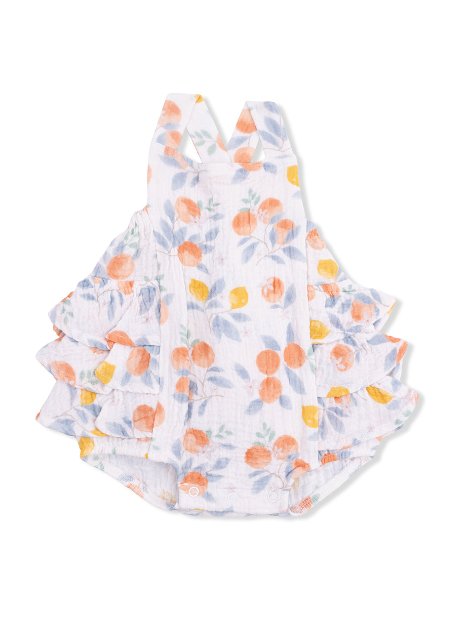 White baby romper with orange and yellow floral design and ruffled layers on the sides.
