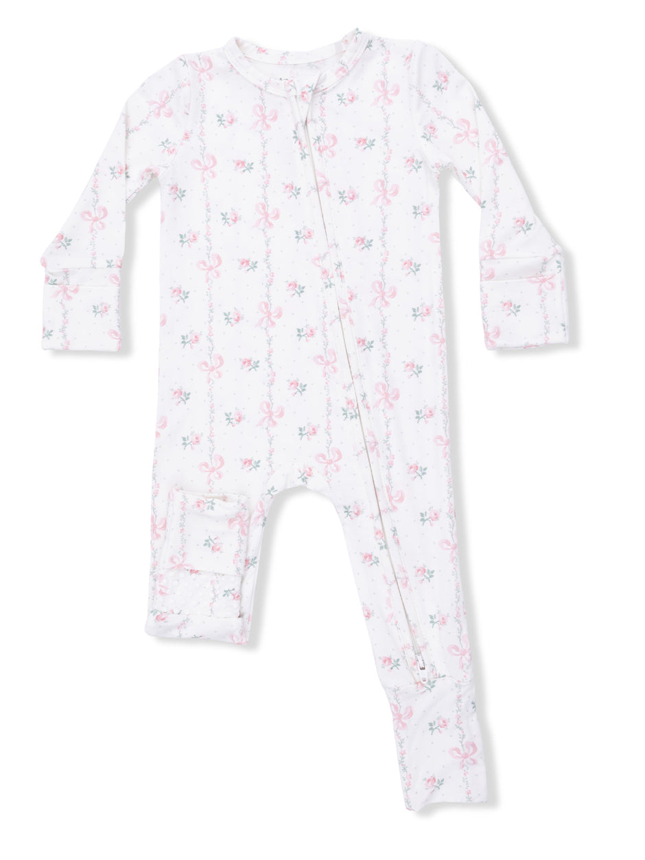 White infant pajamas with pink floral and bow pattern, featuring a front zipper and long sleeves.