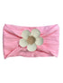 Pink headband with textured fabric and a large white flower embellishment at the center.