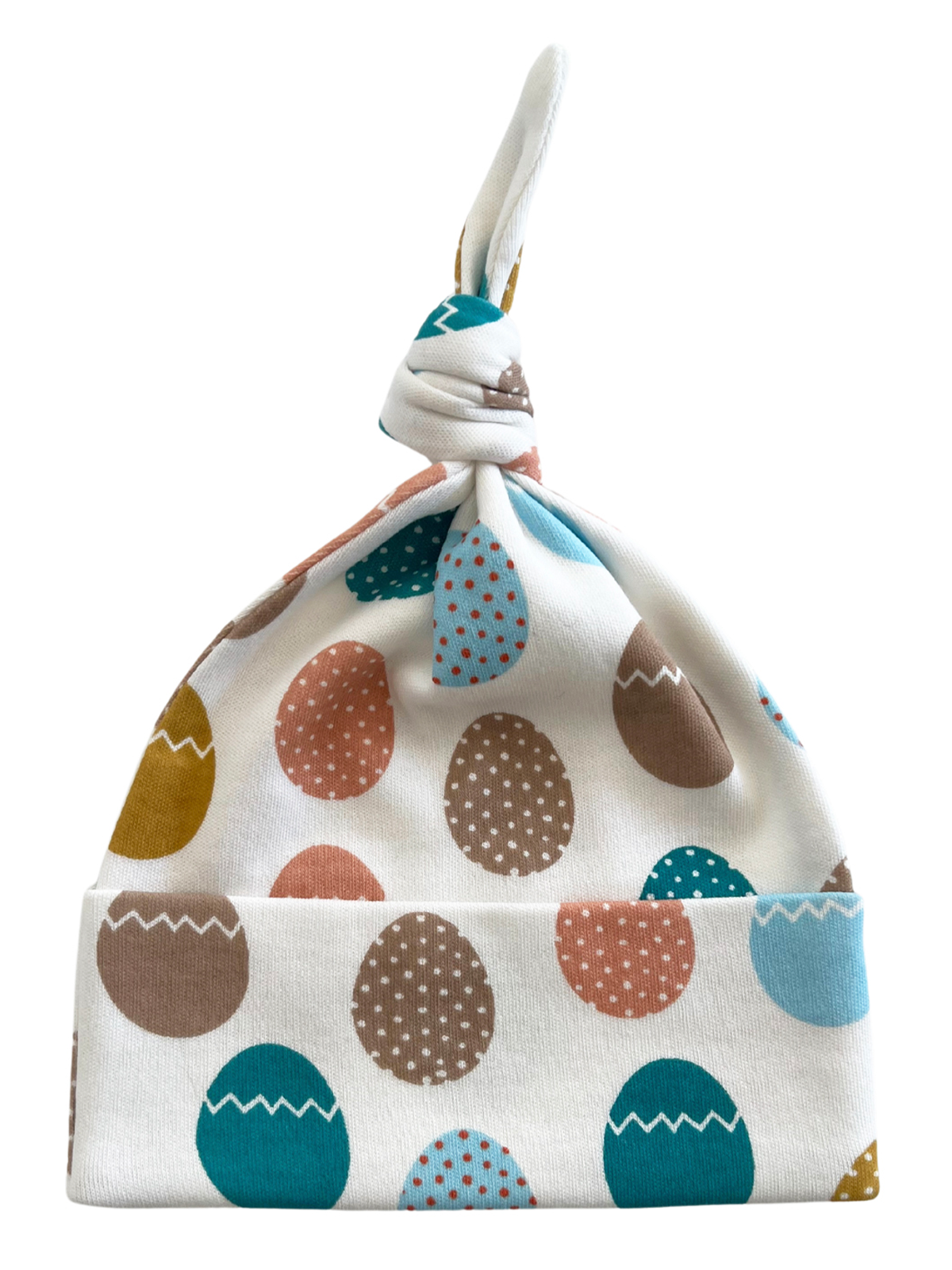 White baby hat with colorful egg patterns, featuring a knot at the top and a folded brim.