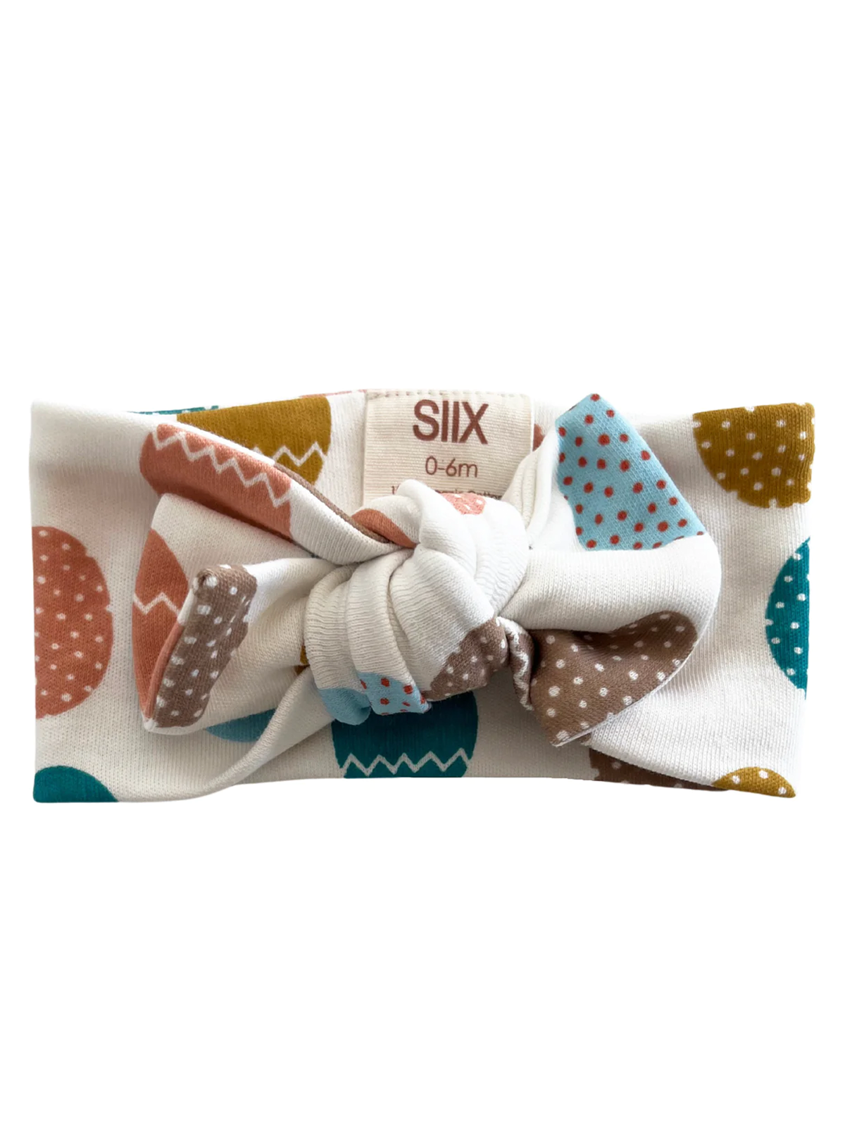 Colorful baby headband with a knot, featuring playful polka dots and geometric patterns on a white background.