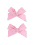 Two pink fabric hair bows with knot detail, displayed side by side on a white background.