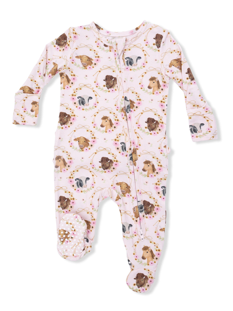Pink baby pajamas with animal prints and footed design, featuring dogs and floral accents. Ideal for infants.