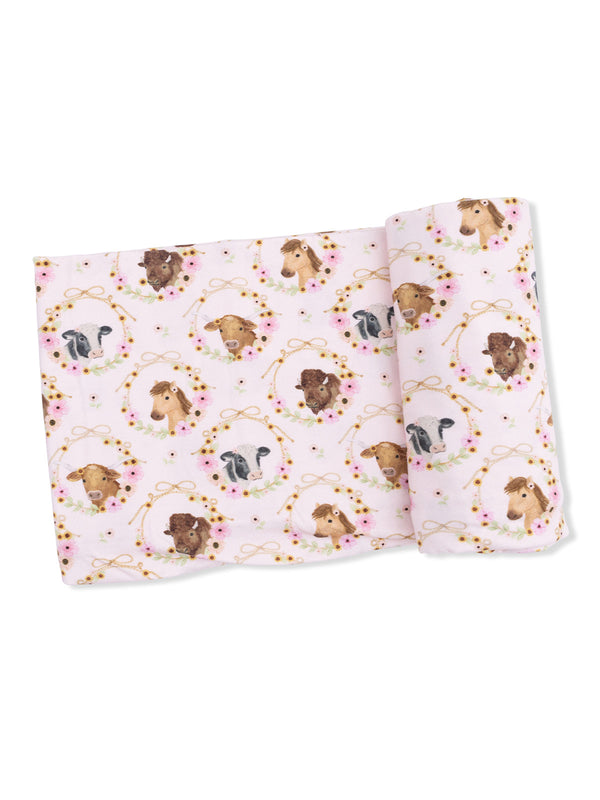 Pink fabric featuring illustrated animal heads in floral wreaths, including cows, horses, and dogs.