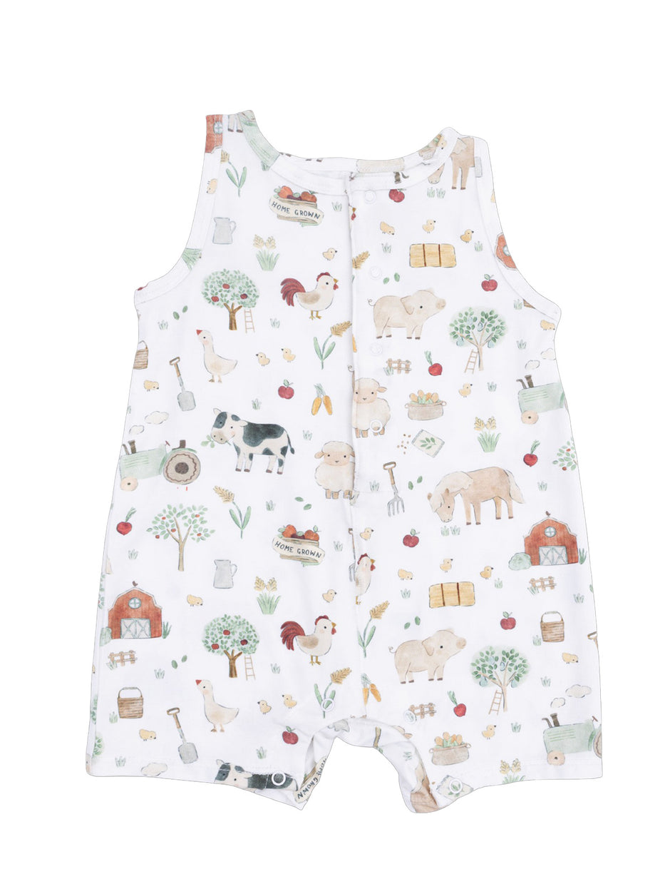 White infant romper featuring a playful farm animal print with trees, vegetables, and barn illustrations.