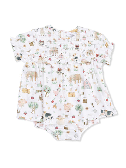 White baby outfit with colorful farm animal patterns and floral designs, featuring ruffled sleeves and a smocked bodice.