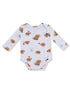 Brown cartoon footballs with faces and colorful accessories on a white onesie. Long sleeves and snap closures.
