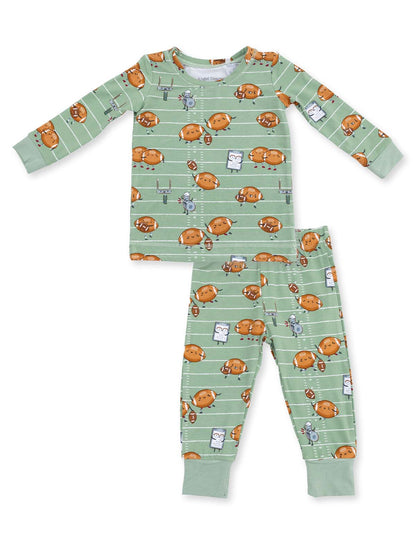 Child's green pajamas featuring cartoon footballs, a referee, and game elements on a striped background.