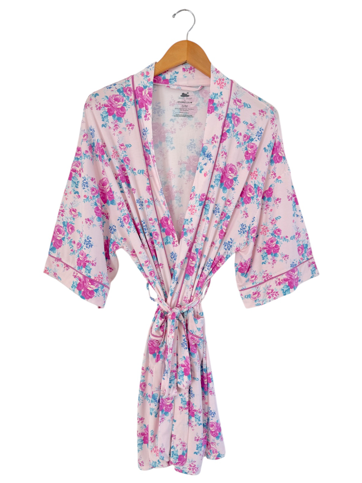 Pink floral robe with short sleeves, featuring a tie waist and hanging on a wooden hanger.